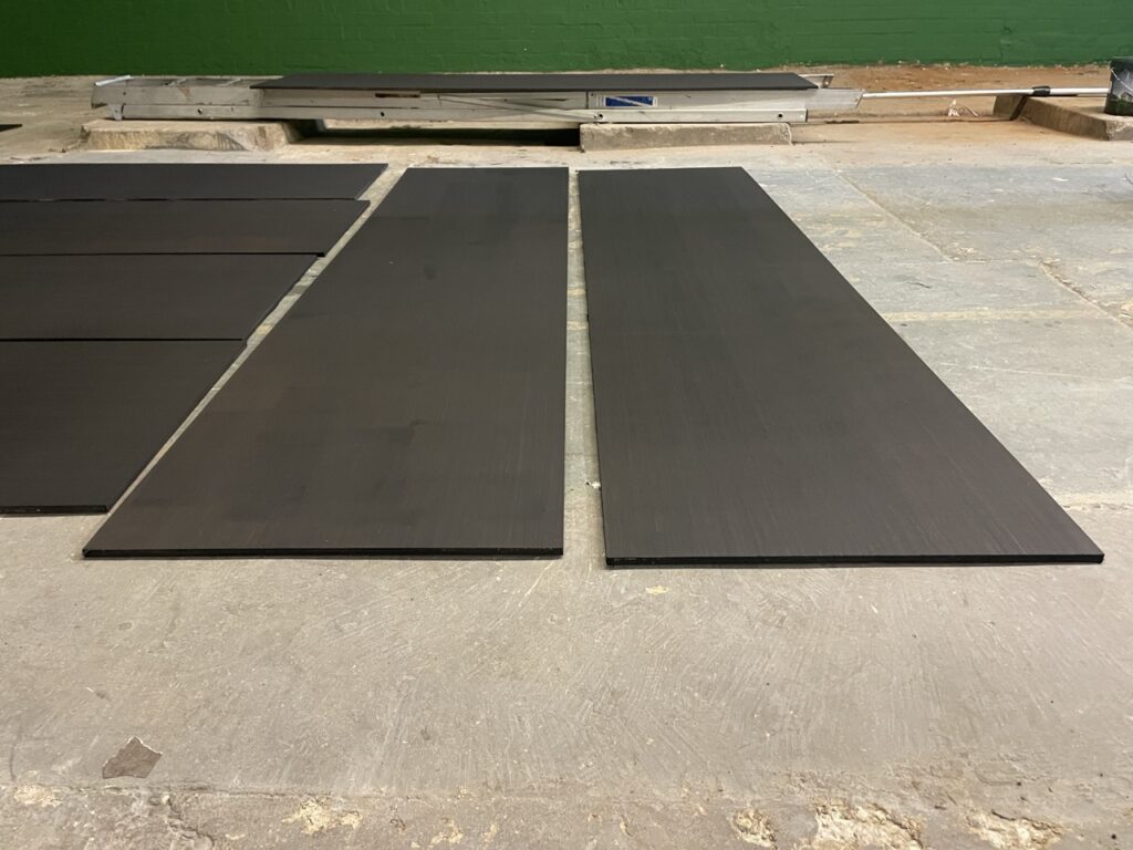 The first of the MDF boards for the 'center line' of the walls arrive, and are painted in dark grey.